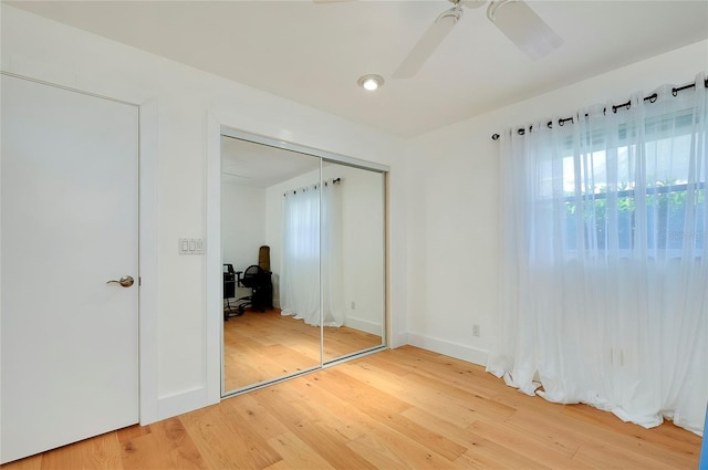 unfurnished bedroom with hardwood / wood-style floors, a closet, and ceiling fan