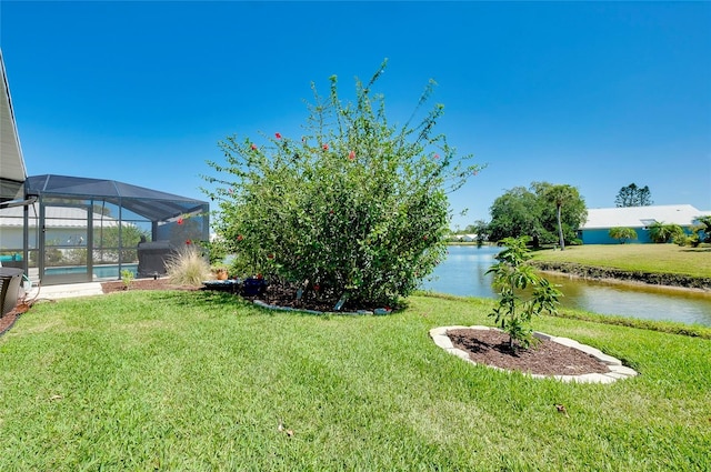 view of yard with a water view and glass enclosure