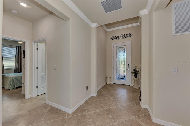 tiled entrance foyer featuring crown molding