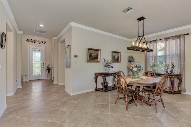 tiled dining space with ornamental molding and an inviting chandelier