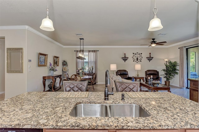 kitchen featuring a kitchen island with sink, decorative light fixtures, and sink