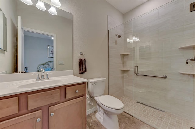 bathroom featuring a shower with door, tile flooring, vanity, and toilet