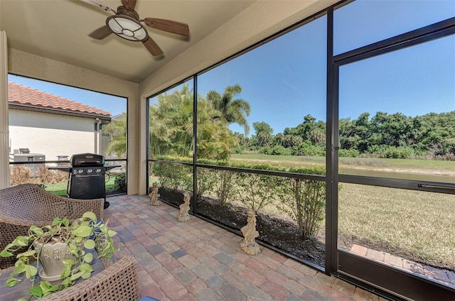 unfurnished sunroom with ceiling fan