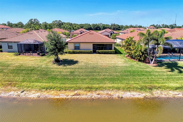 view of front of property featuring a water view, glass enclosure, and a front lawn