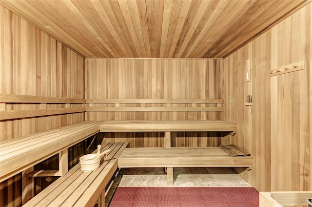 view of sauna / steam room with tile flooring, wood walls, and wood ceiling