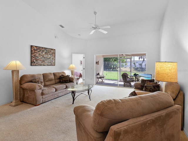 living room with ceiling fan, carpet flooring, and a high ceiling