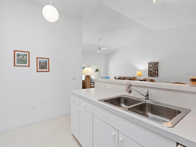 kitchen with ceiling fan, sink, hanging light fixtures, lofted ceiling, and white cabinets