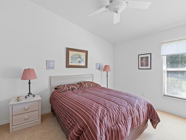 carpeted bedroom with ceiling fan and vaulted ceiling