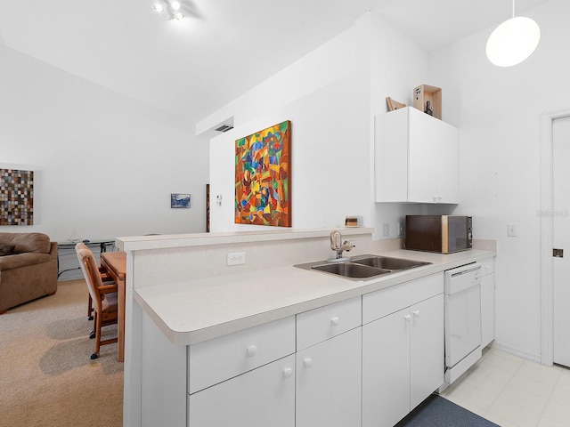 kitchen featuring white dishwasher, white cabinets, sink, hanging light fixtures, and kitchen peninsula