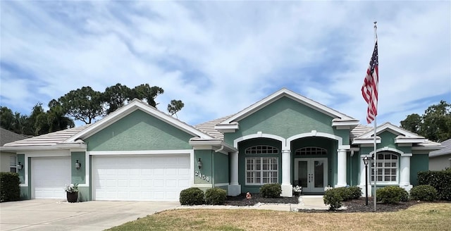 ranch-style house featuring french doors, a garage, and a front lawn