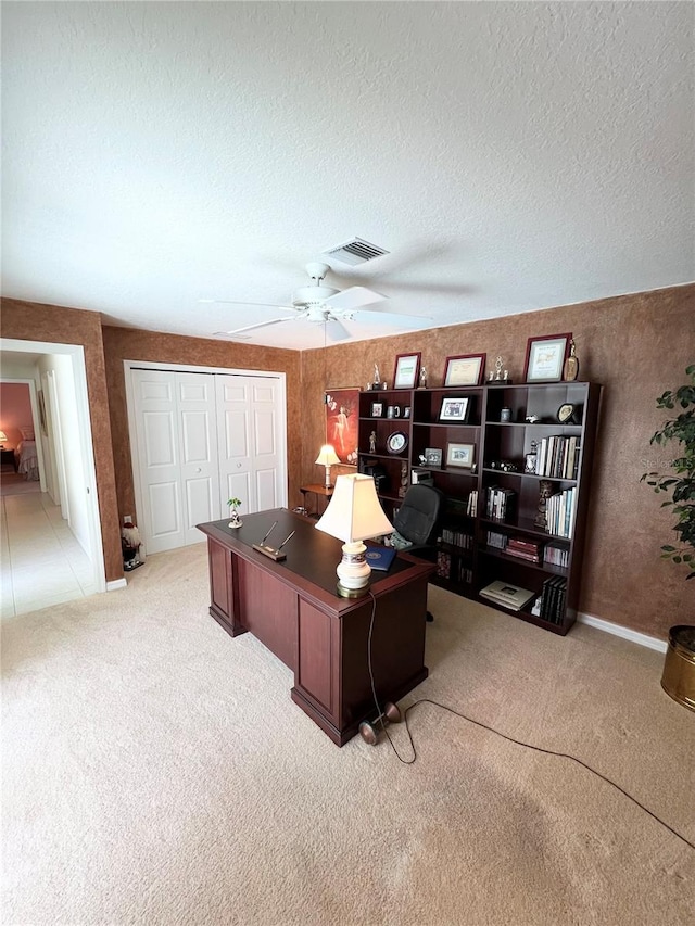 carpeted office featuring ceiling fan and a textured ceiling