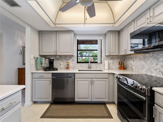 kitchen with dishwasher, range with two ovens, sink, gray cabinets, and ceiling fan