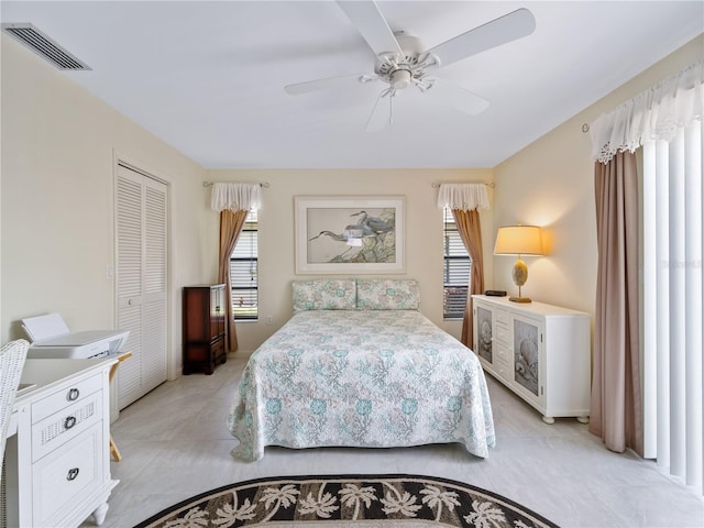 bedroom featuring ceiling fan, multiple windows, and a closet