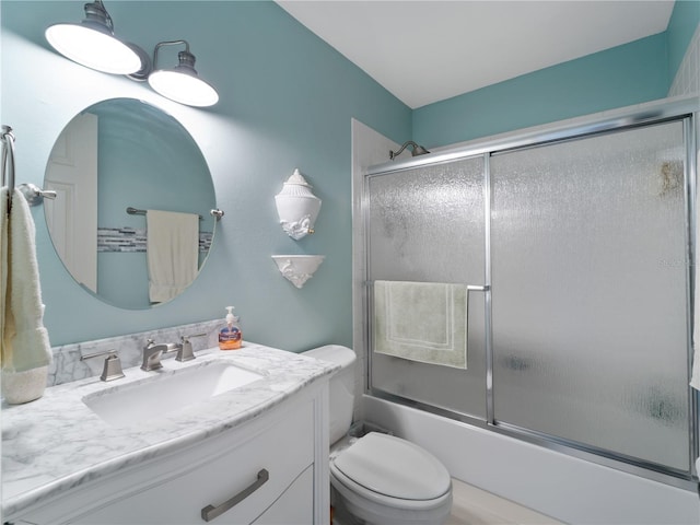 full bathroom featuring toilet, vanity, and enclosed tub / shower combo