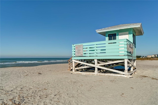 view of outbuilding with a water view and a beach view