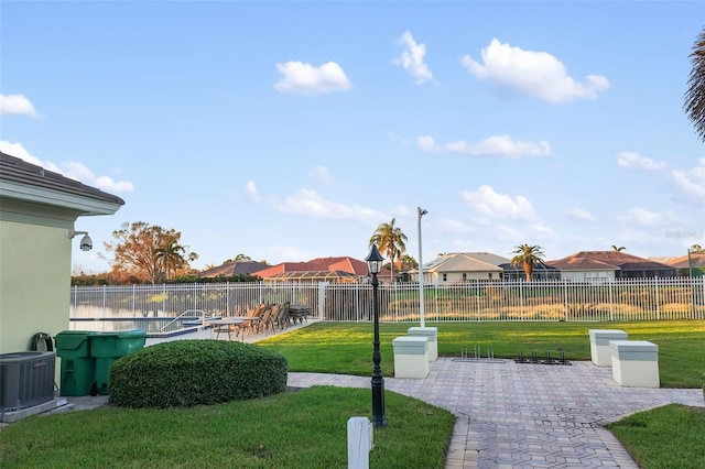 view of property's community featuring a lawn and a patio area