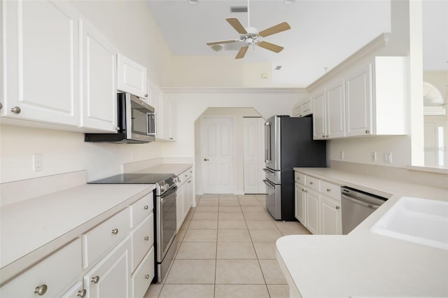 kitchen with appliances with stainless steel finishes, white cabinetry, sink, light tile patterned flooring, and ceiling fan