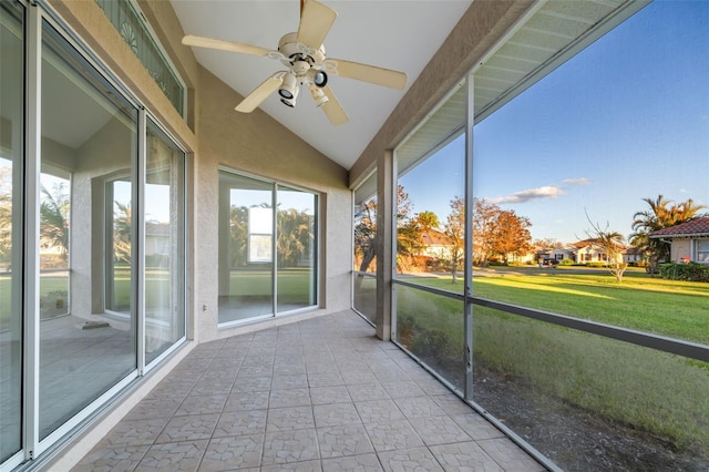 unfurnished sunroom with ceiling fan, lofted ceiling, and a healthy amount of sunlight