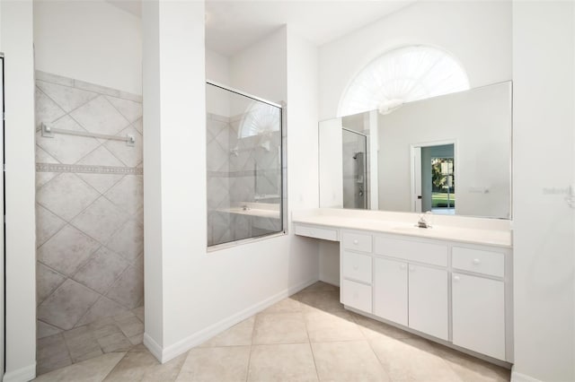 bathroom featuring a tile shower, tile patterned floors, and vanity