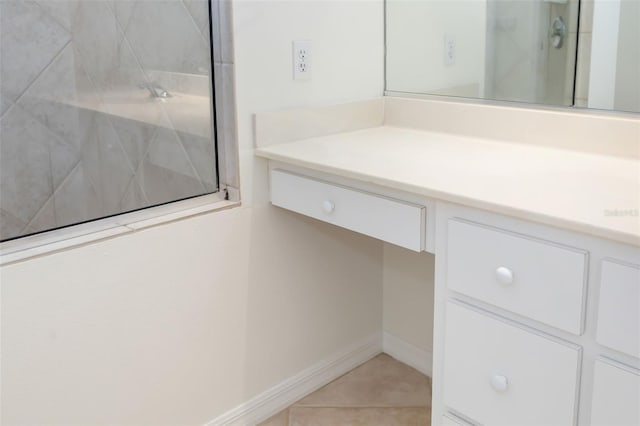 bathroom with tile patterned floors, tiled shower, and vanity