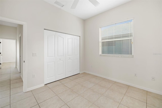 unfurnished bedroom featuring ceiling fan, light tile patterned floors, and a closet