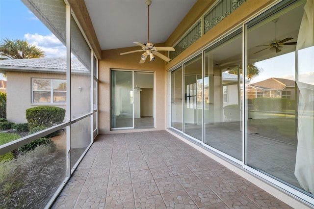 unfurnished sunroom featuring ceiling fan and a wealth of natural light