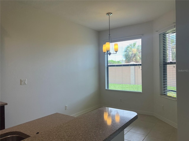 unfurnished dining area with tile floors and an inviting chandelier