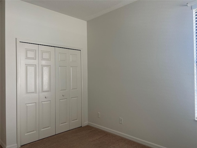 unfurnished bedroom featuring a closet and carpet flooring