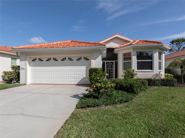 mediterranean / spanish home with a garage and a front yard