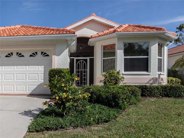 mediterranean / spanish house with a garage and a front lawn