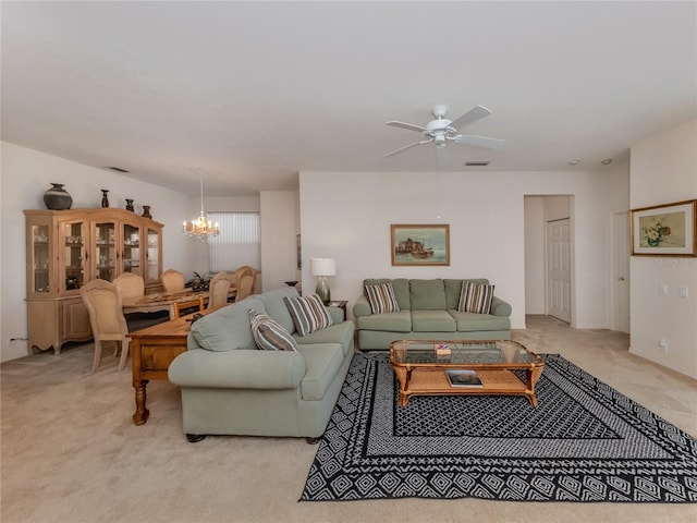 carpeted living room featuring ceiling fan with notable chandelier