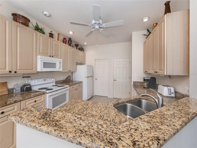 kitchen featuring white appliances, kitchen peninsula, sink, light stone counters, and ceiling fan