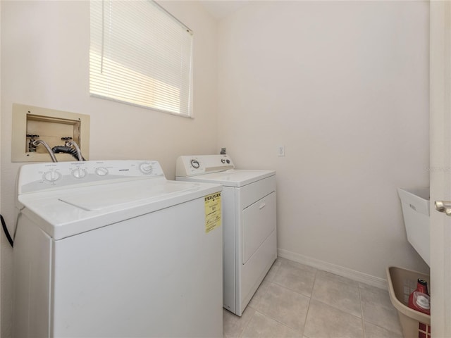 laundry room with independent washer and dryer and light tile flooring