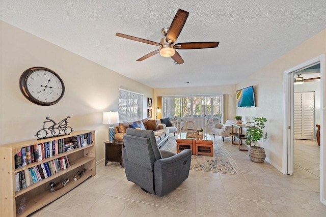 tiled living room featuring ceiling fan and a textured ceiling