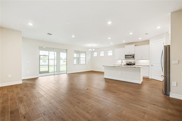 unfurnished living room featuring sink and a chandelier