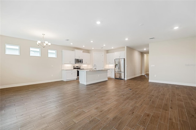 unfurnished living room featuring a notable chandelier and sink