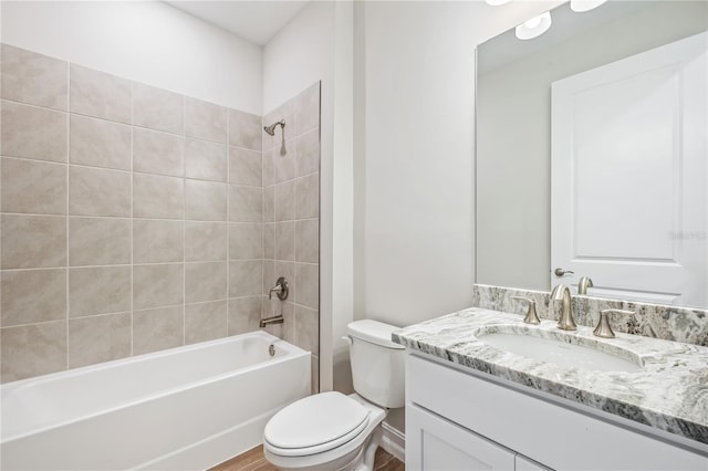 full bathroom featuring hardwood / wood-style flooring, vanity, toilet, and tiled shower / bath