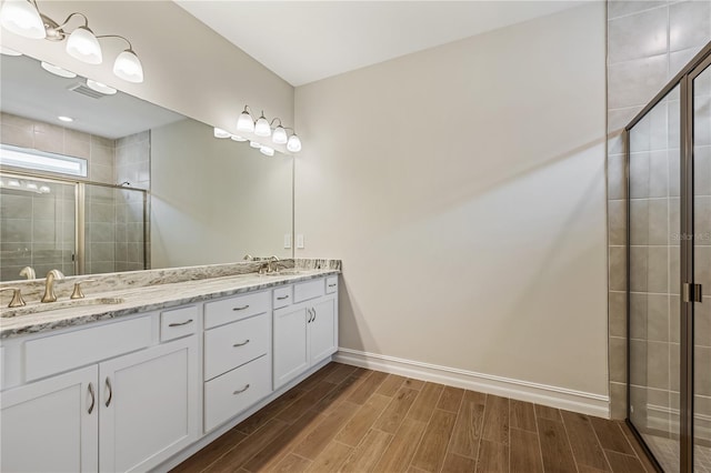 bathroom featuring vanity and a shower with shower door