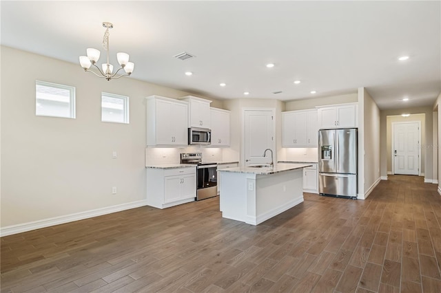 kitchen featuring light stone countertops, stainless steel appliances, white cabinetry, and sink