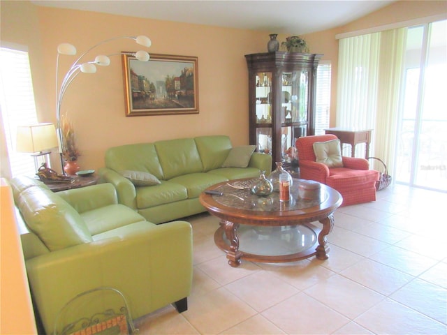 living room featuring plenty of natural light, tile flooring, and lofted ceiling