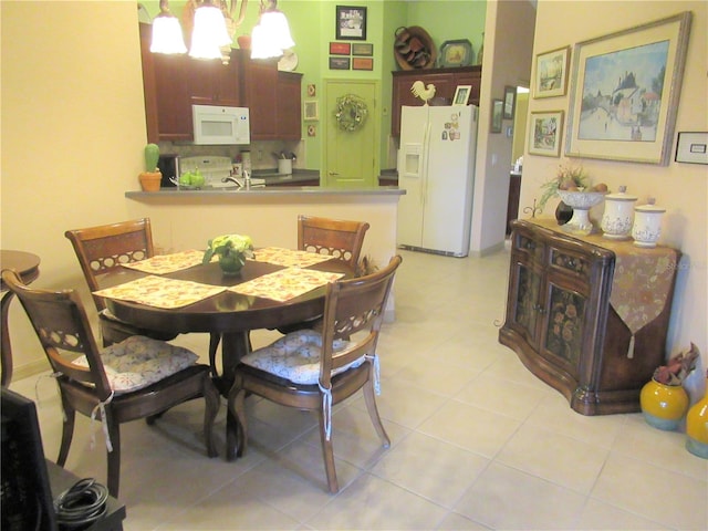 dining area featuring a notable chandelier and light tile floors