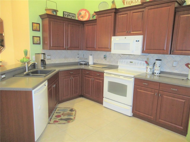 kitchen featuring sink, white appliances, tasteful backsplash, and light tile floors