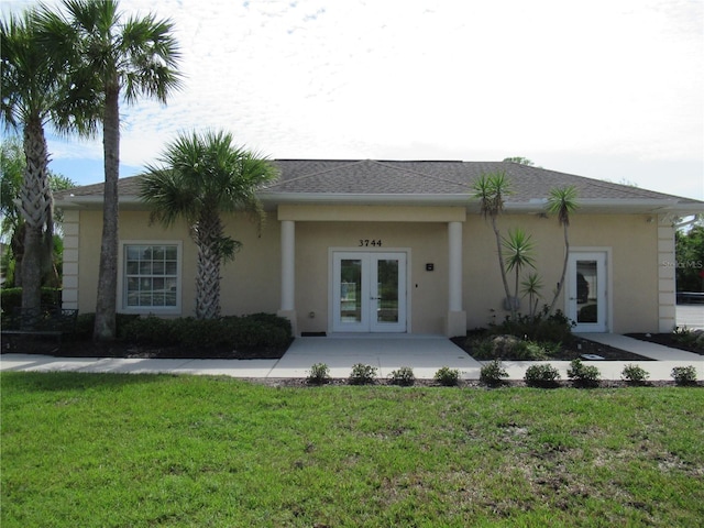 back of house with french doors and a yard