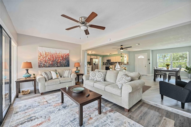 living room featuring ceiling fan and hardwood / wood-style flooring