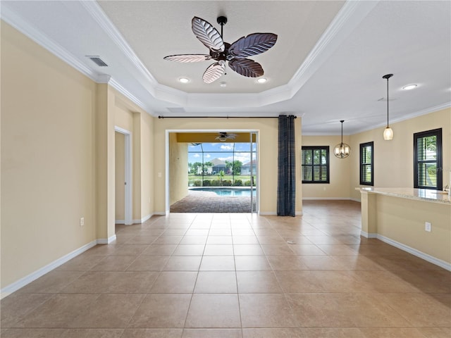 unfurnished room with a raised ceiling, crown molding, light tile patterned floors, and ceiling fan with notable chandelier