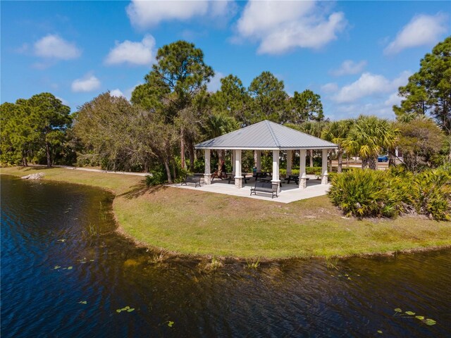 surrounding community with a gazebo, a water view, and a lawn