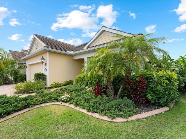 view of front of home featuring a front lawn and a garage