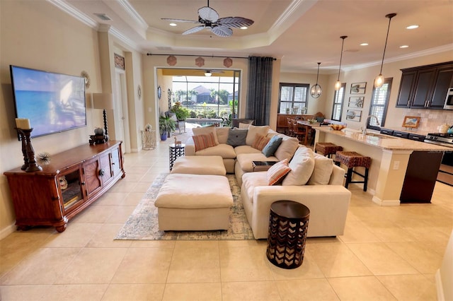 living room featuring a raised ceiling, ceiling fan, crown molding, and light tile patterned floors