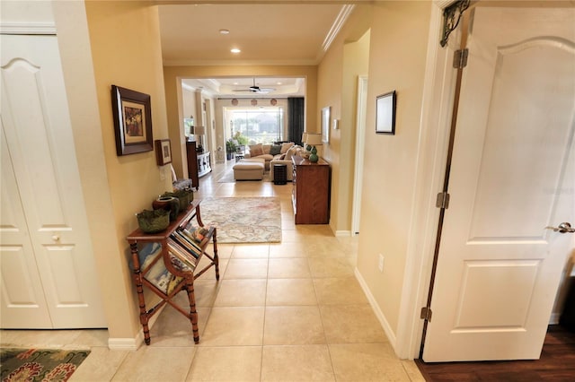 hallway with crown molding and light tile patterned flooring