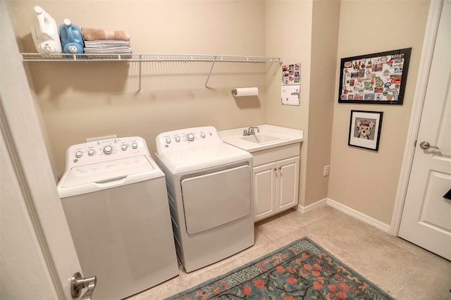 washroom with cabinets, light tile patterned floors, sink, and washing machine and clothes dryer